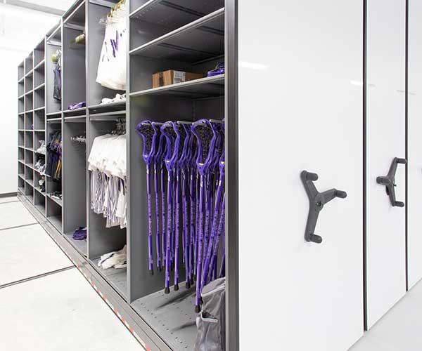 Jerseys and other assorted basketball gear stored on a mechanical assist storage system